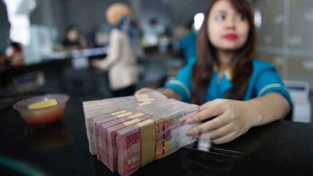 A Teller At A Money Changer Handles Indonesia Rupiah Bank Notes In Jakarta Indonesia Reuter